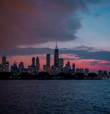 Capture the beauty of Chicago's skyline at dusk, with vibrant skies and illuminated buildings.